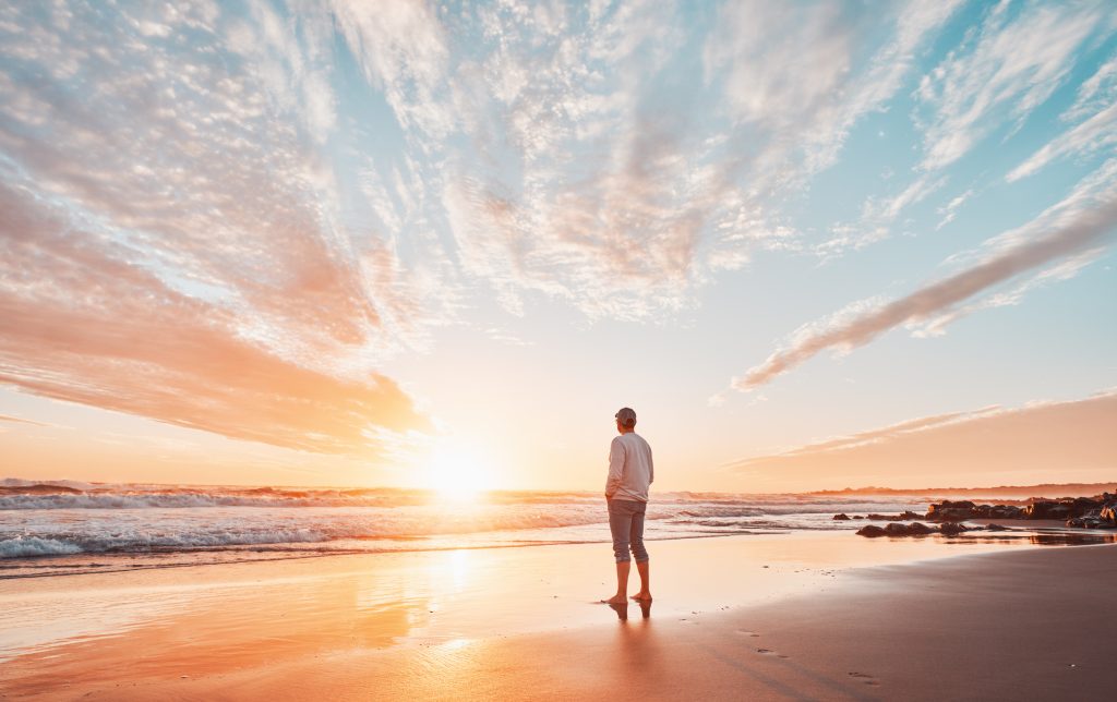 silhouette of a person on the shore of the beach contemplating a beautiful sunset